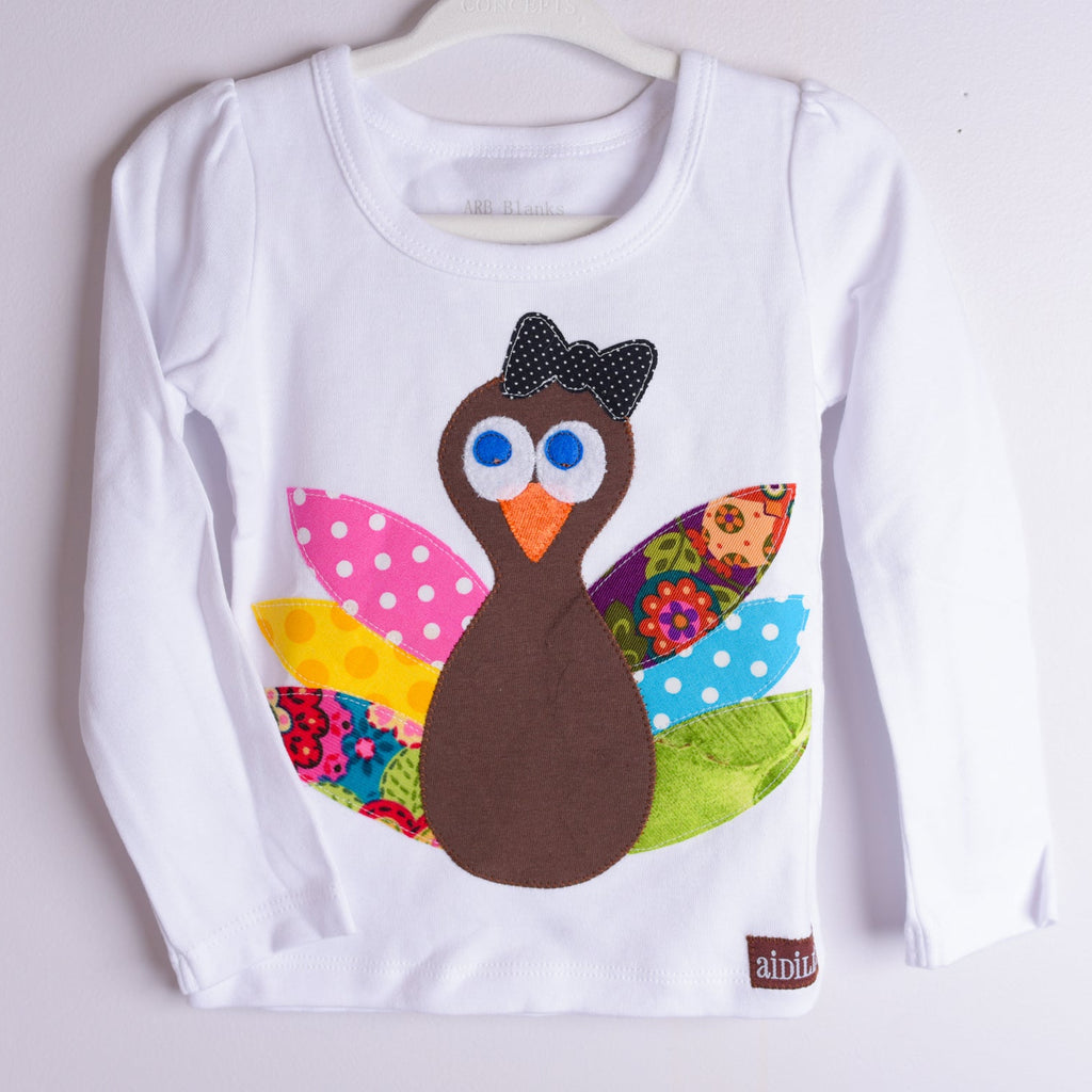 White long-sleeve shirt with a colorful turkey design on a white background