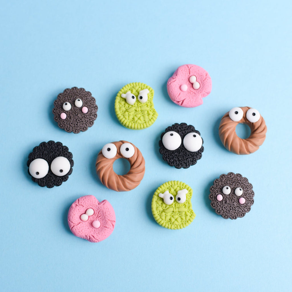 Colorful cookies with googly eyes arranged on a blue background