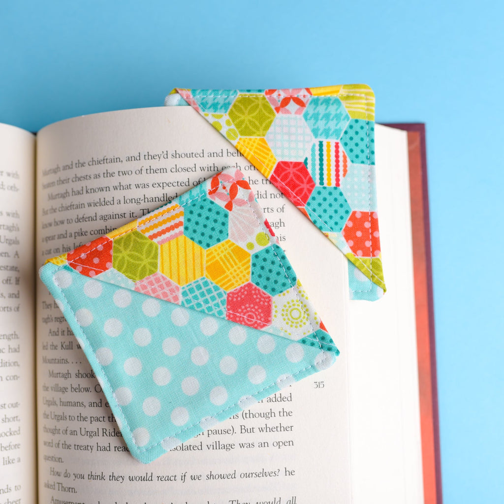 Colorful quilted bookmark on an open book with a blue background