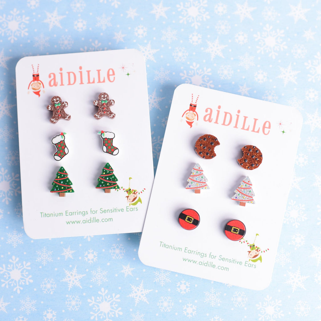 Two cards of Christmas-themed earrings on a snowflake-patterned background