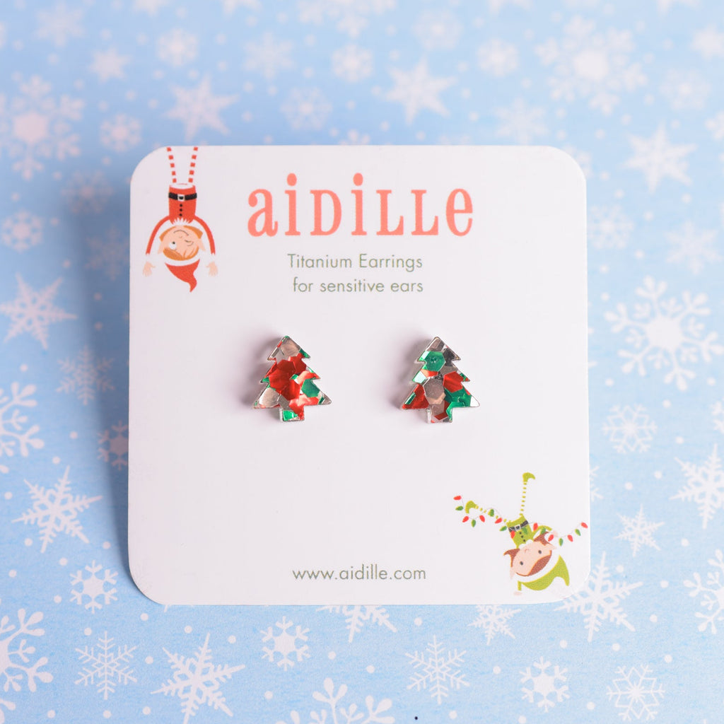 Pair of Christmas-themed earrings on a 'aidille' branded card with a snowflake patterned background.