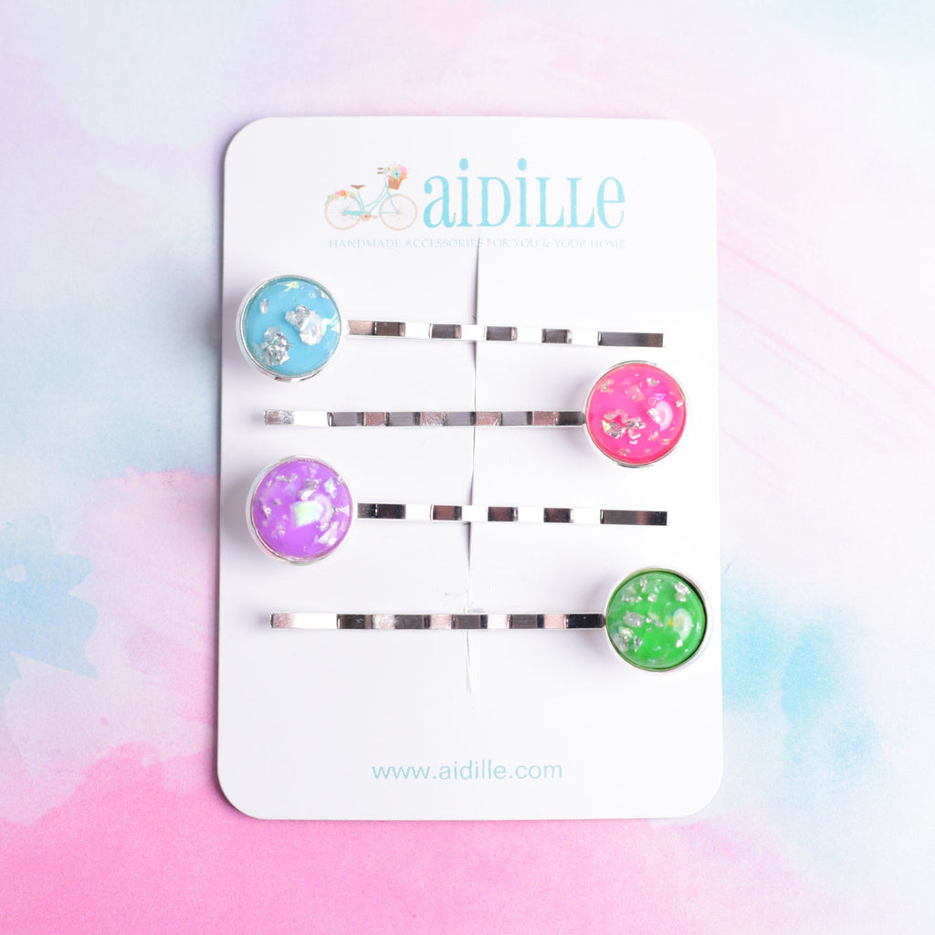 Set of colorful hair clips on a display card with 'aidille' branding against a pastel gradient background.