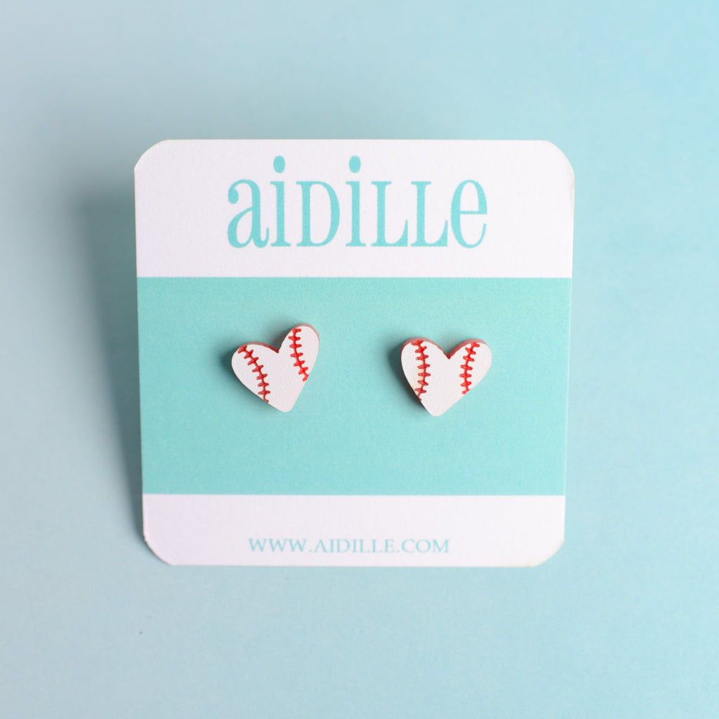 Heart-shaped baseball earrings on a 'aidille' branded card against a light blue background