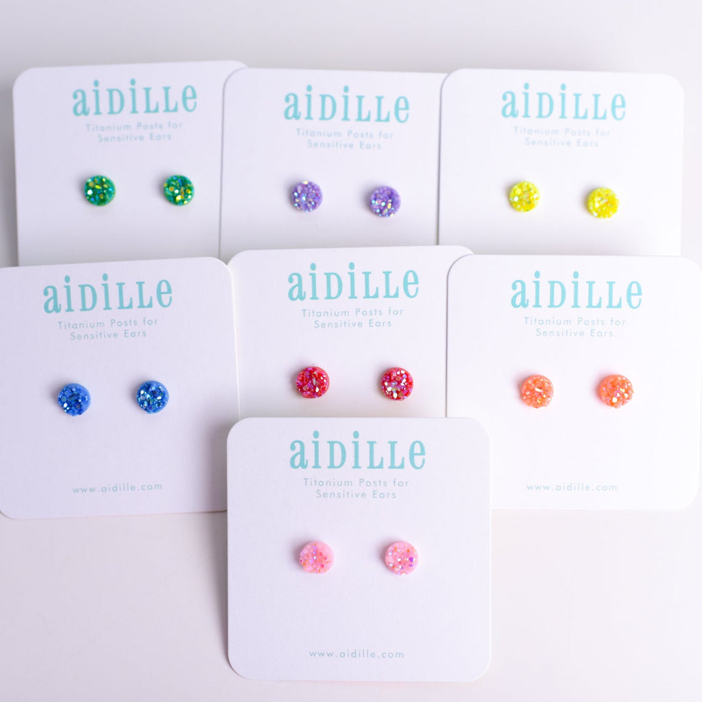 Set of earrings on display with 'aidille' branding on white cards.