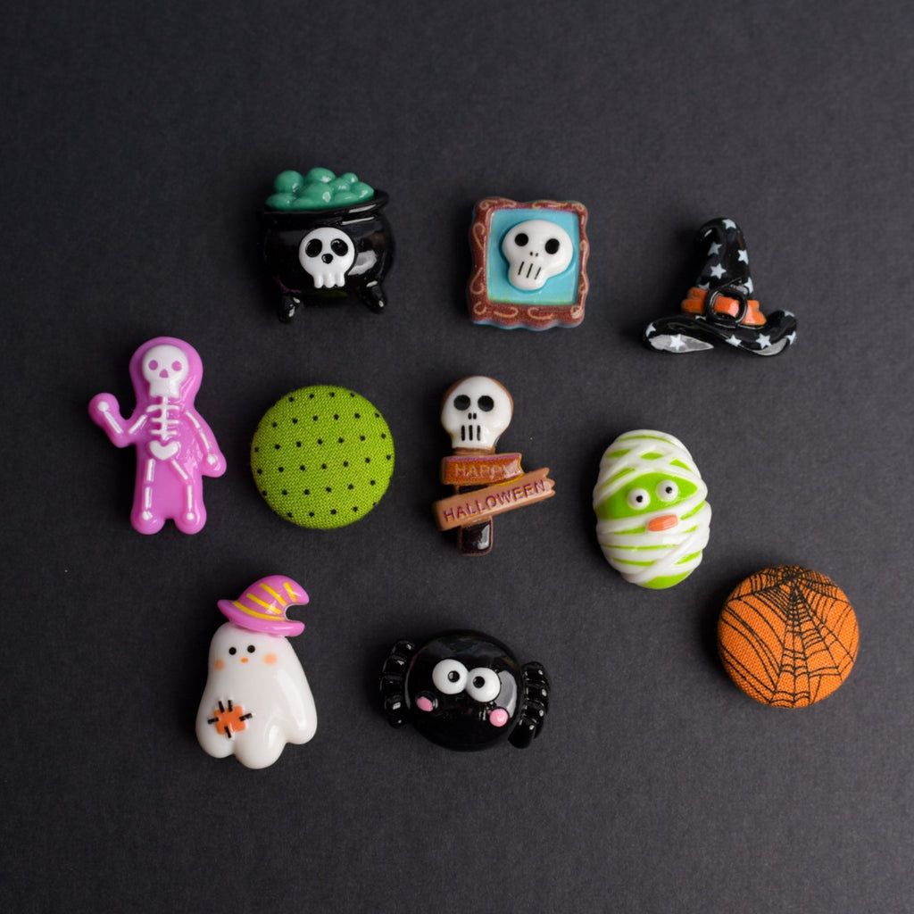 Collection of Halloween-themed decorative pins on a dark background