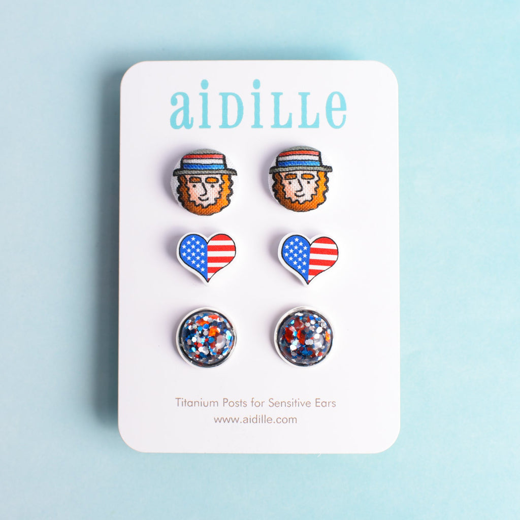 Set of earrings on a 'aidille' branded card with a blue background