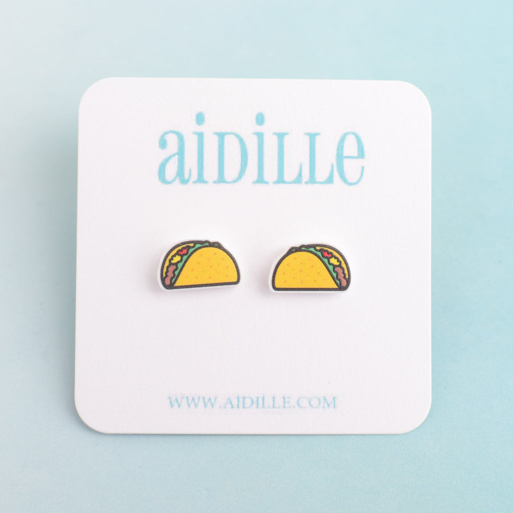 A pair of acrylic taco earrings with titanium posts, displayed on a white square background with 'Aidille' branding.